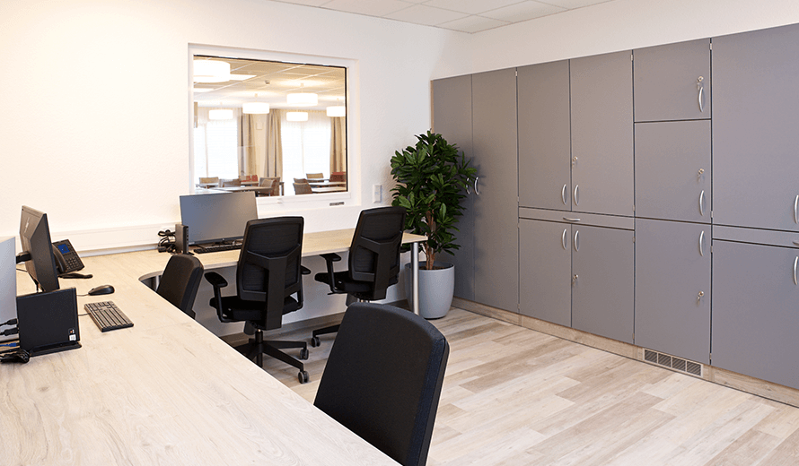 Dienstzimmer einer Pflegeeinrichtung mit Schreibtischen und Bürostühlen in einer räumigen und wohlfühlenden Atmosphäre