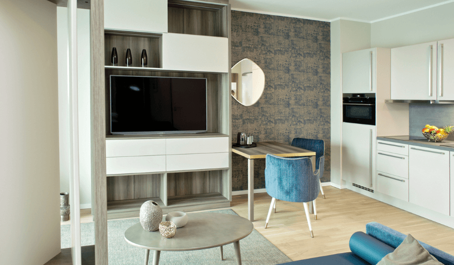 Clevere Raumlösungen für ein Mikroapartment mit Wohn, Büro und TV Wand in einem Raum.