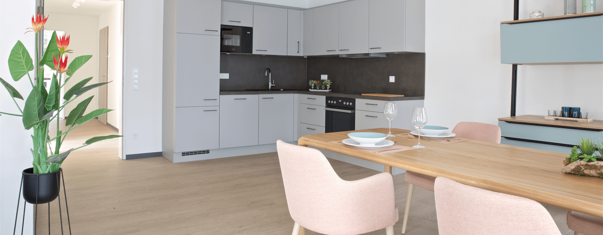 Objekteinrichtung vom Betreuten Wohnen mit einer modernen und barrierefreien Wohnung mit einer Küche, Tisch und Stühlen.