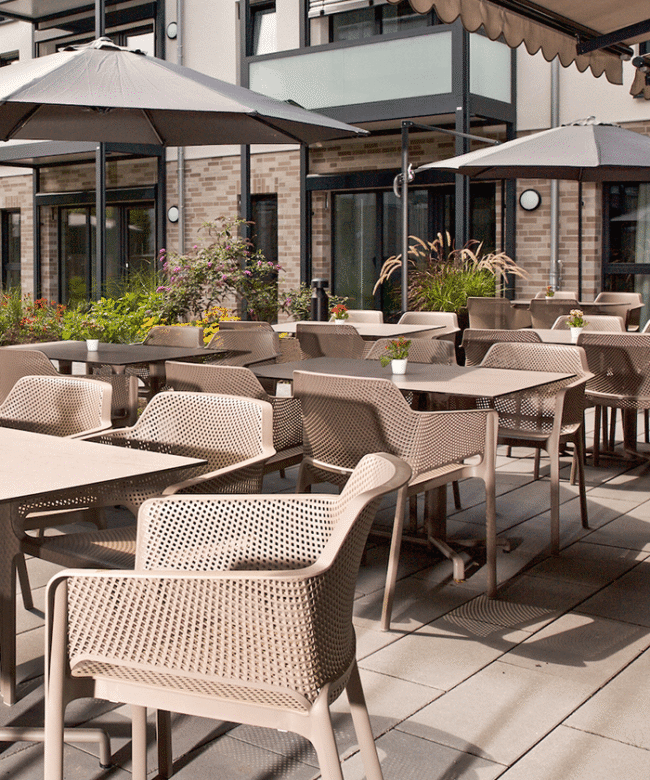 Moderne und pflegeleichte Terrassen mit robusten braunen Stühlen und Tischen.