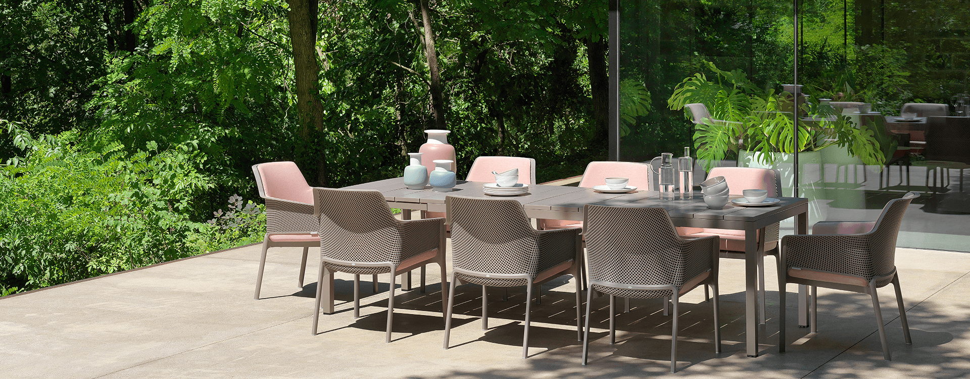Neu gestalteter Terrassenbereich einer Pflegeeinrichtung mit robusten und pflegeleichten Terrassenmöbeln wie Tisch und Stühle in grau.