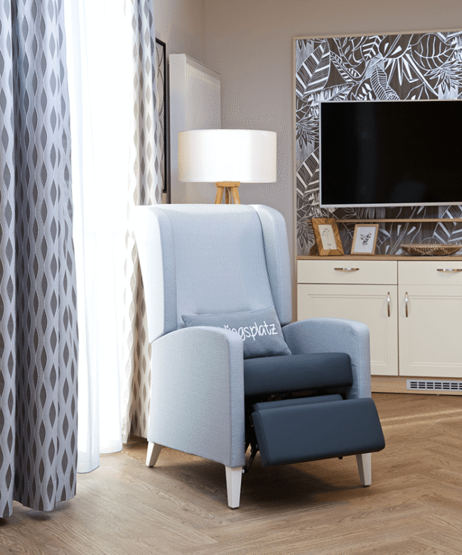 Ein blauer Sessel in einem neu eingerichteten Bewohnerzimmer