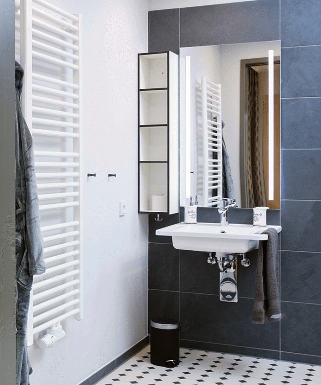 Moderns und funktionales Pflegebad mit blauen Wandfliesen einer Senioreneinrichtung