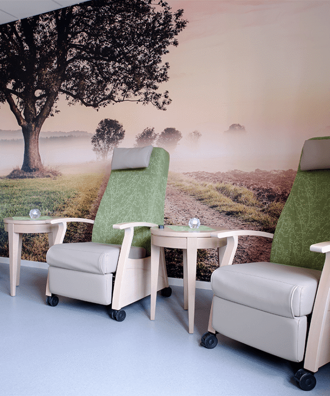 Therapieraum mit einer Naturlandschaft als Fototapete und Therapiestühlen von CARELINE in grün beige.